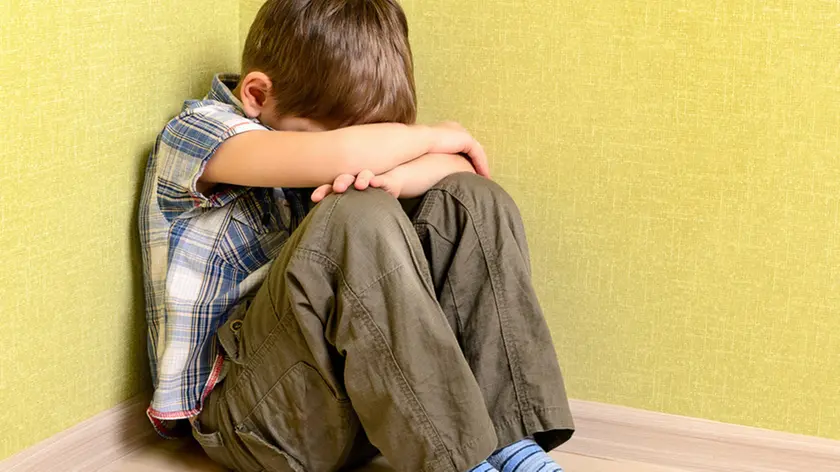 Little child boy wall corner punishment sitting