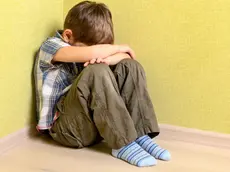 Little child boy wall corner punishment sitting