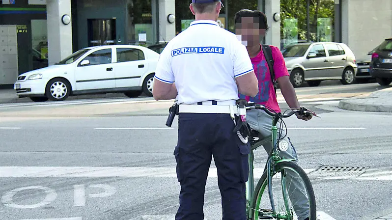 Un agente della Polizia municipale controlla i documenti di un giovane straniero