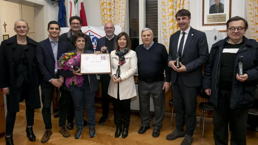 La premiazione al circolo Acli di Ronchi dei Legionari: Lorena Bressa, al centro con fiori e pergamena, assieme alle autorità Foto Katia Bonaventura