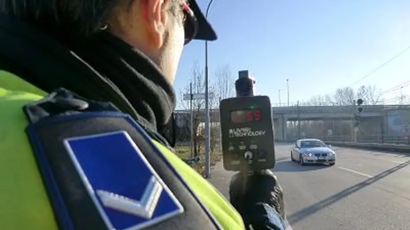 Un agente della polizia locale impegnato nei controlli con il telelaser (foto d'archivio)