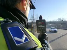 Un agente della polizia locale impegnato nei controlli con il telelaser (foto d'archivio)