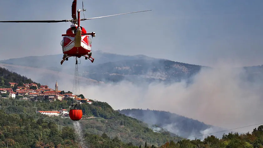 Un elicottero durante le operazioni di spegnimento degli incendi che la scorsa estate hanno mandato in fumo grandi aree dei boschi del Friuli Venezia Giulia