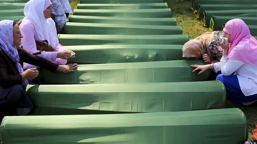 Donne in preghiera sulle tombe di Srebrenica (foto d'archivio)