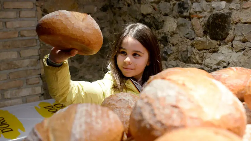 Una bambina con una pagnotta in una foto d’archivio