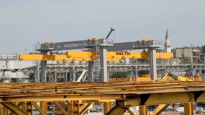 Nella giungla di gru (grue per i vecchi cantierini e nell’eccellente libro “La tuta gialla) svetta il campanile del duomo. In una simbiosi ineluttabile nella città dei cantieri. E delle navi. Foto Bonaventura