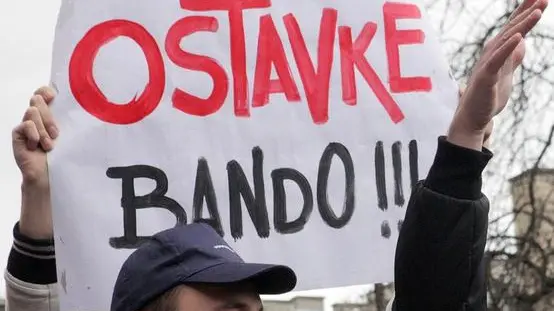 epa04064736 Demonstrators shout slogans during a protest in Sarajevo, Bosnia and Herzegovina, 09 February 2014. Two days after violent protests broke out in the Bosnian capital, people took to the streets again, asking the government to resign. The placard reads 'resignation bandits!!!'. EPA/JASMIN BRUTUS