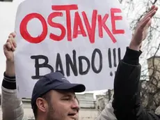 epa04064736 Demonstrators shout slogans during a protest in Sarajevo, Bosnia and Herzegovina, 09 February 2014. Two days after violent protests broke out in the Bosnian capital, people took to the streets again, asking the government to resign. The placard reads 'resignation bandits!!!'. EPA/JASMIN BRUTUS