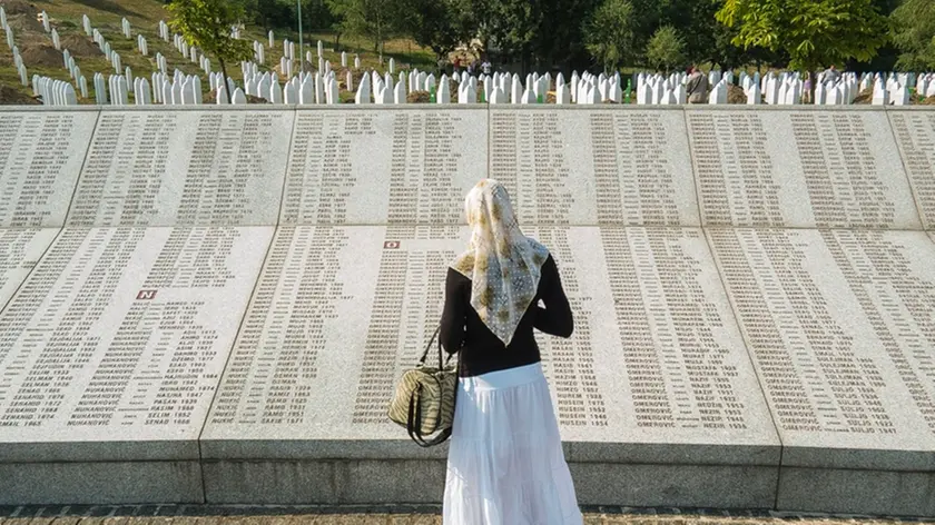 Una donna davanti al memoriale di Srebrenica