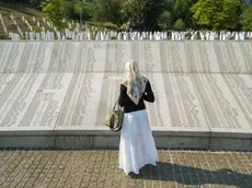 Una donna davanti al memoriale di Srebrenica