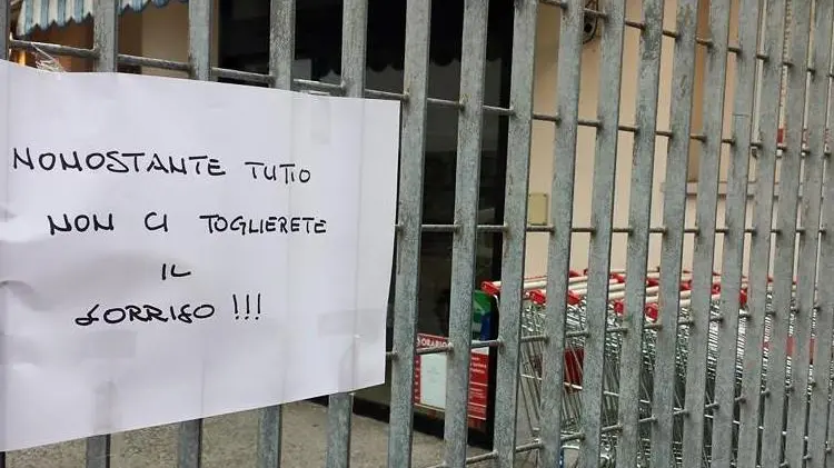 Il cartello attaccato sul cancello del supermercato "Tutto pepe" dopo il furto