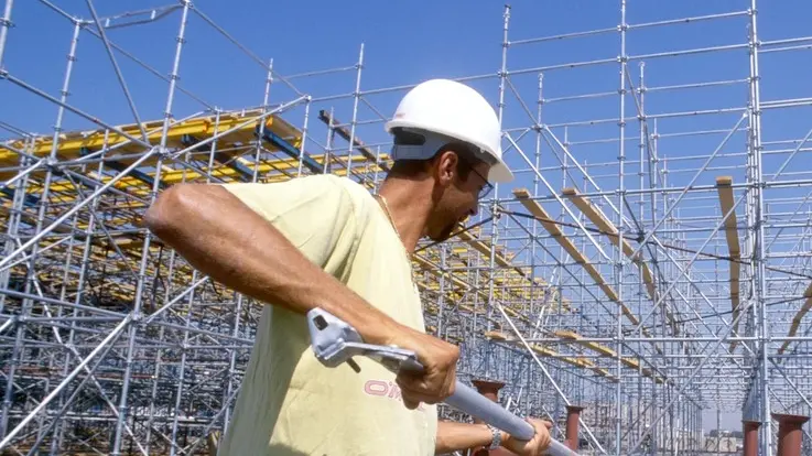 LAVORI EDILI, CANTIERE OPERAIO CON CASCHETTO