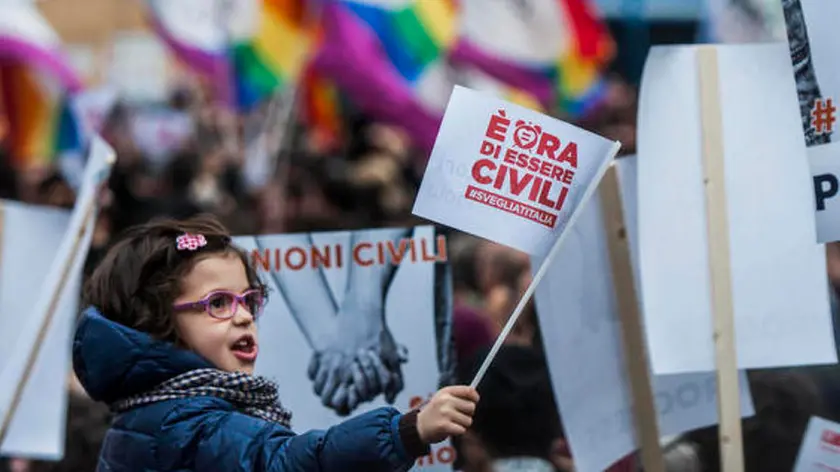 Una bimba con la bandiera che chiede diritti civili per tutti