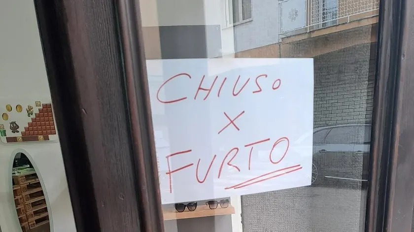 Il cartello “Chiuso per furto” comparso sulla vetrina di Optik Center
