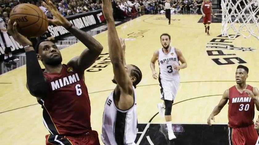 epa04241626 San Antonio Spurs player Kawhi Leonard (R) tries to block a shot against Miami Heat player LeBron James (L) in the second half of the NBA Finals game 1 at AT&T Center in San Antonio, Texas, USA, 05 June 2014. The winner of the best of seven will be NBA Finals Champions. EPA/ERIC GAY/POOL CORBIS OUT