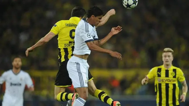 epa03675843 Dortmund's Robert Lewandowski (C-L) vies for the ball with Madrid's Raphael Varane during the UEFA Champions League semi final first leg soccer match between Borussia Dortmund and Real Madrid at BVB stadium Dortmund in Dortmund, Germany, 24 April 2013. EPA/JONAS GUETTLER