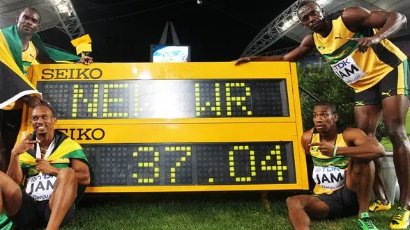 epa02898203 The Jamaican 4x100m relay runners Nesta Carter (standing L), Usain Bolt (standing R), Michael Frater (seated L) and Yohan Blake (seated R) celebrate after setting a new World Record in the men's 4x100m final at the 13th IAAF World Championships in Daegu, Republic of Korea, 04 September 2011. EPA/DIEGO AZUBEL