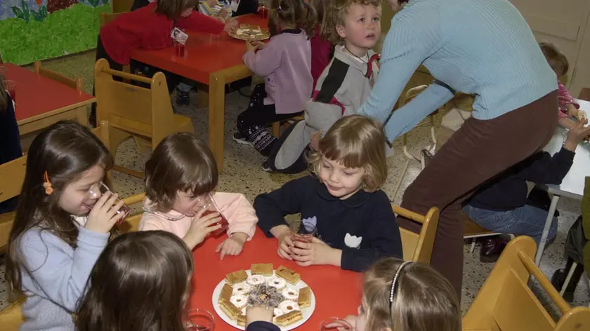 Bambini mangiano assieme all'asilo in una foto di archivio