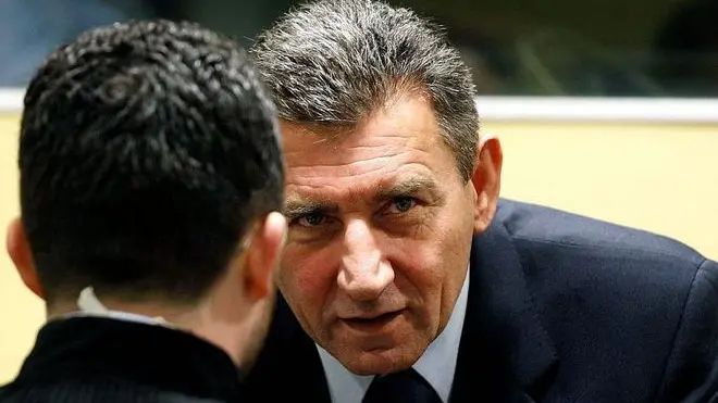 Ante Gotovina (R), who was commander in the Split district of the Croatian army, talks in the courtroom of the International Criminal Tribunal for the former Yugoslavia (ICTY) before his appeal judgement in The Hague November 16, 2012. The appeals court overturned on Friday the conviction of Gotovina, the most senior Croatian military officer charged with war crimes during the Balkan conflict of the 1990s. Gotovina had been jailed for 24 years. The conviction of Mladen Markac, a Croatian police commander who had been serving an 18-year sentence, was also overturned. REUTERS/Bas Czerwinski/Pool (NETHERLANDS - Tags: CRIME LAW CONFLICT POLITICS)