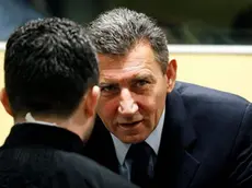 Ante Gotovina (R), who was commander in the Split district of the Croatian army, talks in the courtroom of the International Criminal Tribunal for the former Yugoslavia (ICTY) before his appeal judgement in The Hague November 16, 2012. The appeals court overturned on Friday the conviction of Gotovina, the most senior Croatian military officer charged with war crimes during the Balkan conflict of the 1990s. Gotovina had been jailed for 24 years. The conviction of Mladen Markac, a Croatian police commander who had been serving an 18-year sentence, was also overturned. REUTERS/Bas Czerwinski/Pool (NETHERLANDS - Tags: CRIME LAW CONFLICT POLITICS)