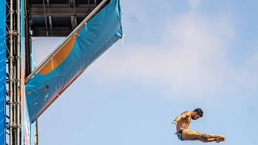 Due dei tuffatori del circulito Red Bull Cliff Diving intenti nelle loro acrobazie dalla piattaforma da 27 metri. Lo spettacolo sarà replicato a Trieste nel fine settimana