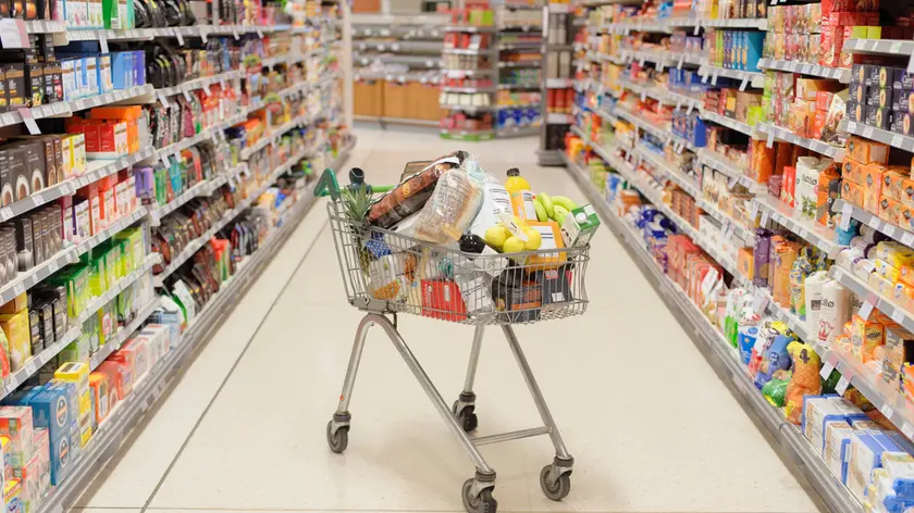 Full shopping cart in supermarket aisle