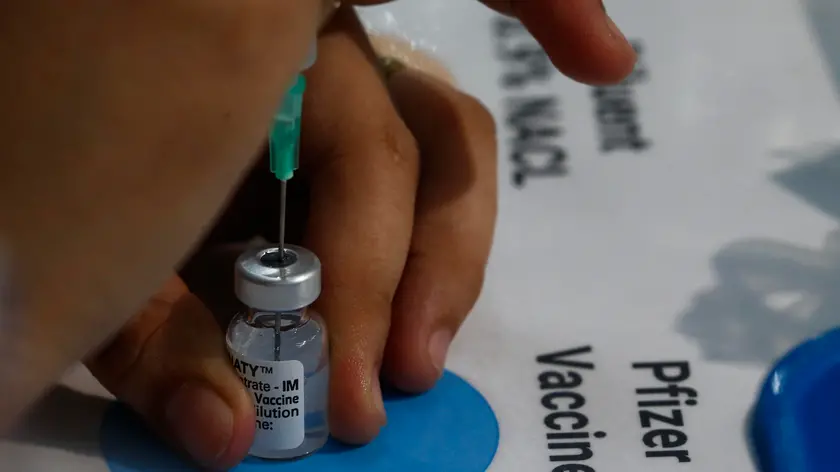 epa09214211 A city health office worker prepares a vial of Pfizer COVID-19 vaccine during an inoculation drive in Marikina City, Metro Manila, Philippines, 20 May 2021. The Department of Health is working with local government units to suspend early announcements of vaccine brands available for scheduled vaccination dates and instead inform citizens right before inoculation in order to get consent. The move is aimed at encouraging equal confidence in all available vaccines and avoid overcrowding in inoculation centers caused by brand preference. EPA/ROLEX DELA PENA