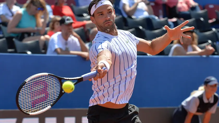 In this photo taken Saturday, June 20, 2020, Grigor Dimitrov from Bulgaria returns the ball to Croatia's Borna Coric during their semifinal match at a tournament in Zadar, Croatia. Dimitrov says he has tested positive for COVID-19 and his announcement led to the cancellation of an exhibition event in Croatia where Novak Djokovic was scheduled to play on Sunday. (AP Photo/Zvonko Kucelin)