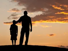 Un'immagine simbolo: padre e figlio osservano il tramonto