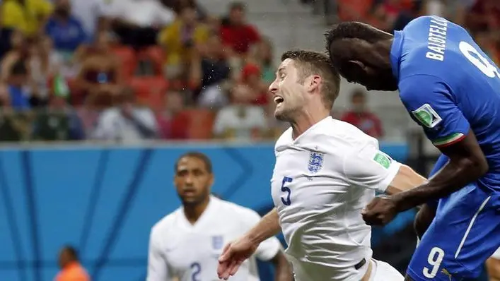 epa04257776 Italy's Mario Balotelli (R) scores the 1-2 past England's Gary Cahill (C) during the FIFA World Cup 2014 group D preliminary round match between England and Italy at the Arena Amazonia in Manaus, Brazil, 14 June 2014. (RESTRICTIONS APPLY: Editorial Use Only, not used in association with any commercial entity - Images must not be used in any form of alert service or push service of any kind including via mobile alert services, downloads to mobile devices or MMS messaging - Images must appear as still images and must not emulate match action video footage - No alteration is made to, and no text or image is superimposed over, any published image which: (a) intentionally obscures or removes a sponsor identification image; or (b) adds or overlays the commercial identification of any third party which is not officially associated with the FIFA World Cup) EPA/MAST IRHAM EDITORIAL USE ONLY